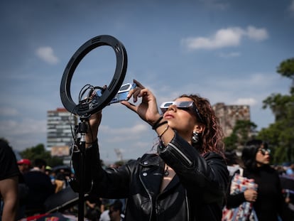 Una mujer observa el eclipse de sol anular que se vio de forma parcial en Ciudad de México el 14 de octubre De 2023.