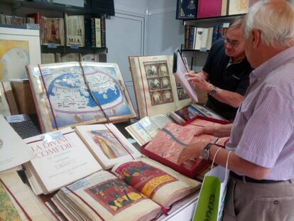 Un cliente consulta facsímiles en una caseta de la Feria del Libro de Madrid.