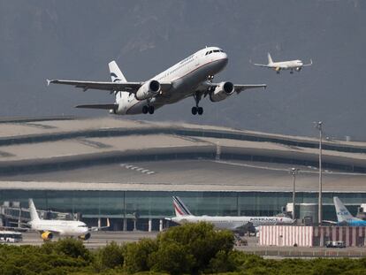 Un avión despega mientras otro aterriza simultáneamente en el aeropuerto del Prat.