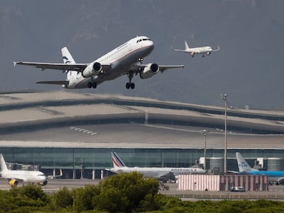 Un avión despega mientras otro aterriza simultáneamente en el aeropuerto de El Prat.