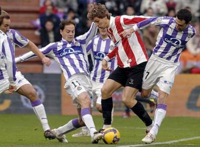 Llorente defiende el balón rodeado por jugadores del Valladolid.