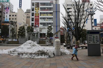 Una niña camina por una plaza de Koriyama donde está instalado un contenedor Geiger que mide un nivel de radiación de 0.162 microsievert por hora.