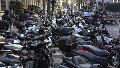 Numerosas motos aparcadas en la acera de la calle Diputació. 