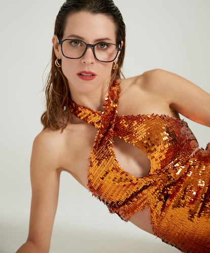 Con montura masculina y la elegancia del negro, con el modelo Oasis de Mango, disponible en Opticalia, un mono de lentejuelas como este de Genny y pendientes de Tous, es fácil brillar en cualquier fiesta.