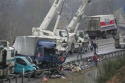 Dos grandes gras retiran varios de los camiones accidentados ayer en el puerto de Etxegarate.