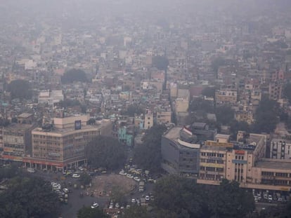 Nueva Delhi, cubierta de aire contaminado, durante el episodio de alerta del 1 de noviembre. A la izquierda, niños a la salida de un colegio de la capital, el pasado miércoles.