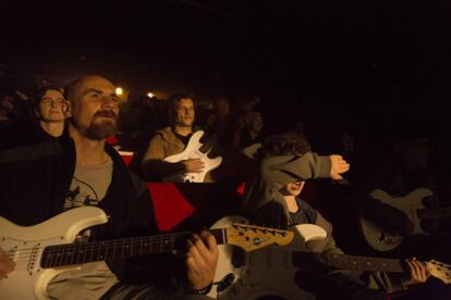 Público de ‘Anarchy’ tocando guitarras eléctricas durante una función.