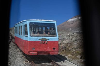 Un grupo de visitantes viaja en un funicular mientras descienden de una plataforma de observación en el Monte Baekdu. Para los historiadores extranjeros, Kim Il Sung pasó la mayor parte de la guerra en el exilio, luchando contra las fuerzas japonesas en la China ocupada y luego al mando de un batallón soviético.