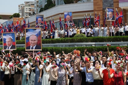 Ciudadanos norcoreanos saludan a la caravana del presidente ruso.