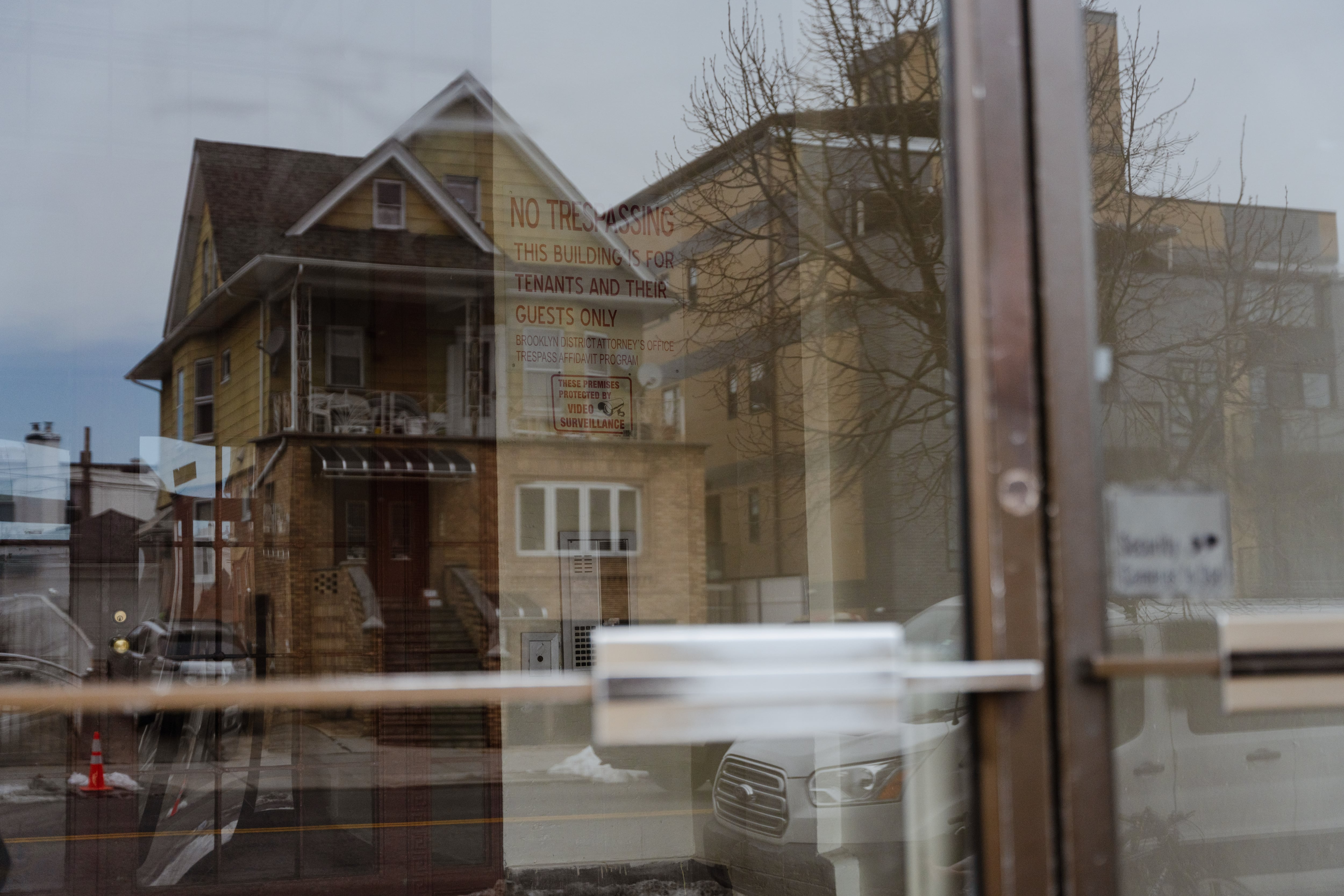 Las casas vecinas se reflejan en la entrada del edificio donde vivía Sebastián Renoj en el momento de su detención por el ICE. 
