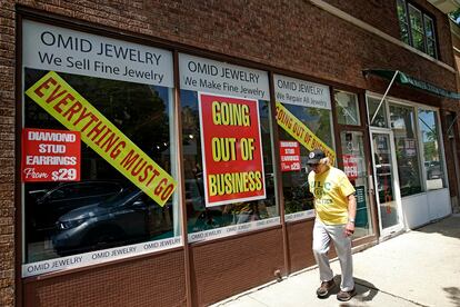 Un hombre camina junto a una tienda que echa el cierre en Winnetka (Illinois, EE UU).