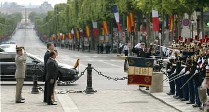 Los Reyes don Felipe y doña Letizia acompañados por el presidente, François Hollande (en primer término), durante la tradicional ofrenda ante la tumba del soldado desconocido que han realizado bajo el Arco del Triunfo de París, como parte del programa oficial de la primera visita de Estado del reinado, que fue suspendida en marzo como consecuencia del siniestro del Airbus de Germanwings y que ahora coincide con el aniversario del anuncio de abdicación de don Juan Carlos.