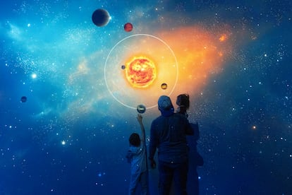 Un padre y sus dos hijos juegan en la sala interactiva Sistema Solar y Cosmovisión.