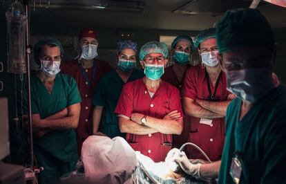 El cirujano Manuel López Santamaría, en el centro con uniforme rojo, junto a su equipo. Acaban de concluir un trasplante de hígado de una madre a su bebé. Miran con atención la ecografía, donde esperan la confirmación de que la operación se ha realizado con éxito.