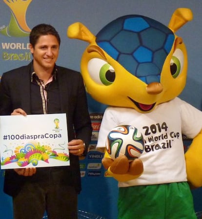 Edmilson, ex internacional brasileño y campeón del mundo en 2002, posa junto a la mascota de Brasil 2014.