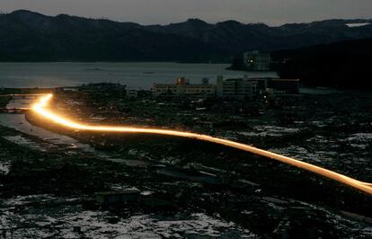 Vehículos iluminan una carretera de la ciudad de Minamisanriku, destruida por el tsunami.