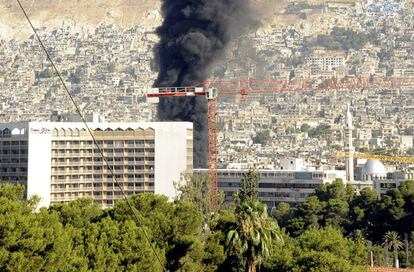 Foto facilitada por la agencia oficial de noticias siria, Sana, que muestra el humo que se eleva tras  explosión registrada cerca del hotel de los observadores de la ONU en Damasco, Siria