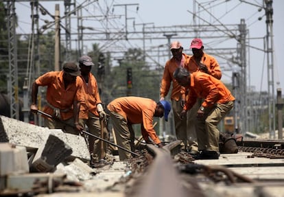 Un grupo de trabajadores del ferrocarril repara un tramo de vía en Ghatkopar, Mumbai (India).