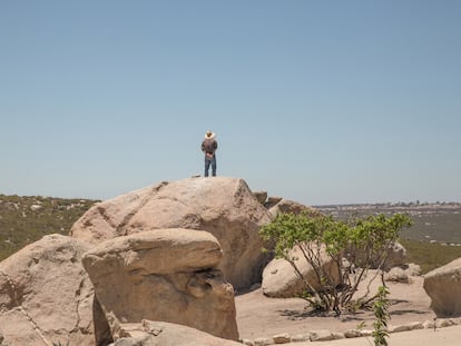 Un vigilante sobre una roca en los límites del centro rehabilitación controla que ningún interno intente escaparse. A unos pocos kilómetros puede apreciarse el muro que divide Estados Unidos de México.