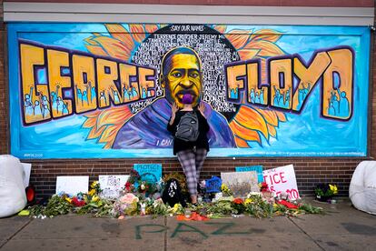 Damarra Atkins pays respect to George Floyd at a mural at George Floyd Square in Minneapolis