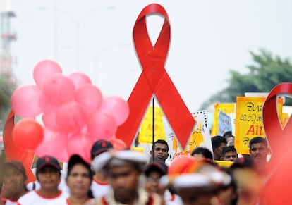 Prisioneros de Sri Lanka participan en una manifestación portando pancartas y lazos rojos.