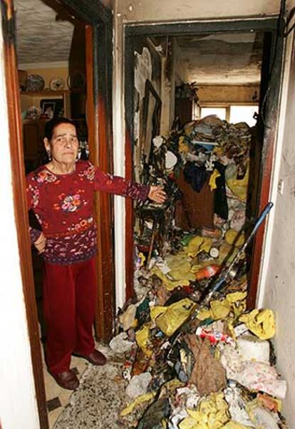 Una vecina de la casa incendiada muestra la basura acumulada.