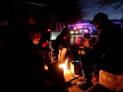 Una familia calienta tortillas en una pequeña hoguera a las afueras de su casa en Monterrey, afectada por el apagón masivo.