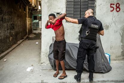 Un policía del CORE (Coordinadora de Recursos Especialess de la Policía Civil) revisa a un habitante del Complexo da Maré, en Río de Janeiro.
