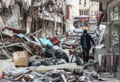 Un niño camina haciéndose paso entre los escombros en Kahramanmaras, Turquía.