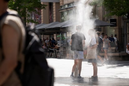 Varias personas se refrescan, este lunes 2 de agosto en Viena. 