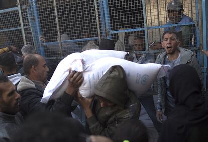 Un hombre carga sacos de harina en un centro de distribución de la UNRWA en Jan Yunis, este jueves.