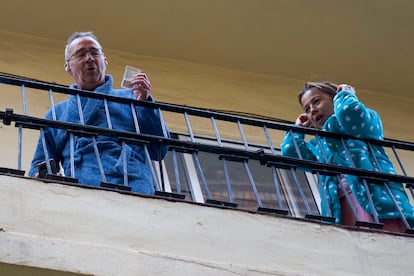 Dos de los premiados con el premio más madrugador de la mañana —el número 54274, el primer quinto premio repartido— han salido a la terraza de su vivienda a celebrar su suerte con albornoz y bata