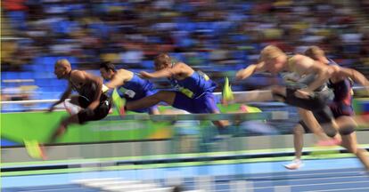 Atletas compiten en los 110 m obstáculos.