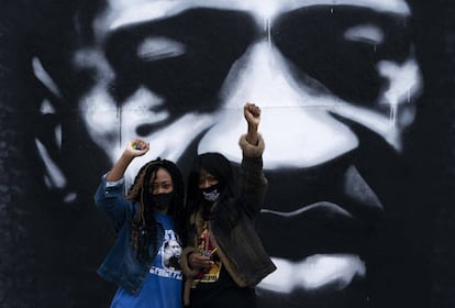 Duas mulheres em frente a um mural de George Floyd em Minneapolis, em outubro.