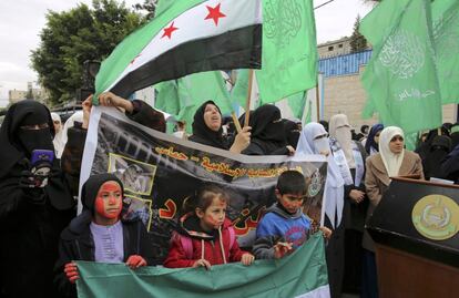 Varios ciudadanos palestinos defensores de Hamas levantan banderas sirias mientras otros llevan banderas islámicas verdes, durante una manifestación frente a la oficina del Alto Comisionado de las Naciones Unidas en Gaza, el 15 de diciembre de 2016.
