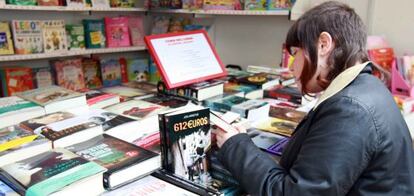 Una joven mira los libros de uno de los puestos instalados en el paseo del Arenal, en la 43ª Feria del Libro de Bilbao.