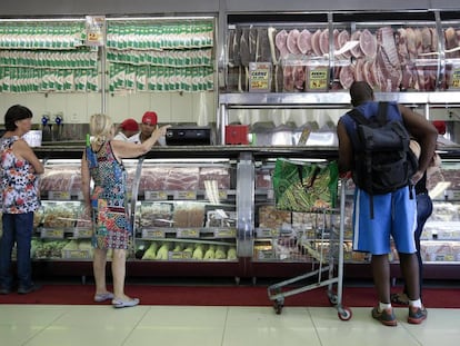 Clientes compram carne num agouçe em São Paulo.
