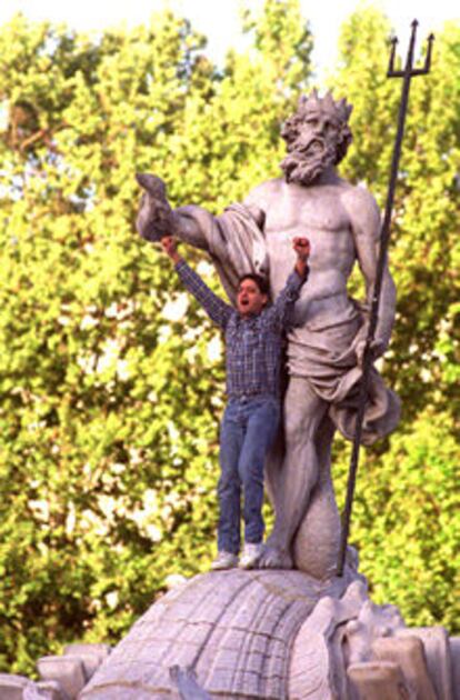 Un aficionado, subido a la fuente de  Neptuno.