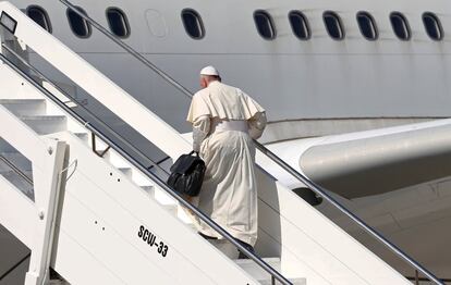 El papa Francisco sube por las escaleras para acceder al avión.