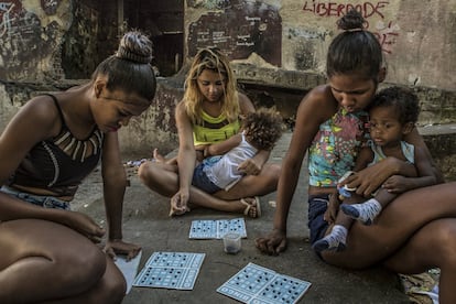 Várias mães entre 16 e 18 anos jogam bingo usando feijões pretos como marcadores. Todas moram no edifício abandonado do IBGE. Favela da Mangueira, Rio de Janeiro. Nas favelas há 25% de mães solteiras. Ao longo dos últimos 10 anos, produziu-se um aumento de 15% no número de nascimentos de mães entre 15 e 19 anos. No Brasil, todo ano cerca de 700.000 jovens desta faixa etária se tornam mães.