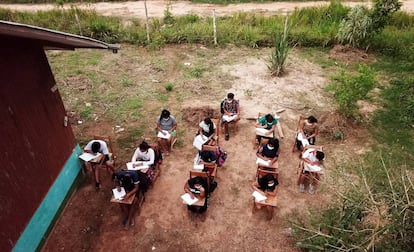 Alumnos de la Amazonía peruana escuchan la clase desde un altavoz y rellenan los ejercicios.