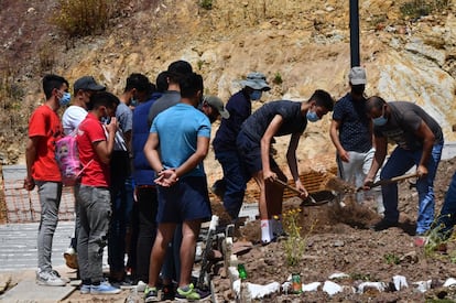 Un grupo de jóvenes, muchos de ellos menores, entierran el cadáver que apareció el pasado lunes por la tarde en la playa del Tarajal, en el cementerio musulmán de Sidi Embarek en Ceuta.