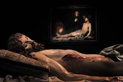 Cristo yacente, escultura policromada de Gregorio Fernández, y, al fondo, <i>Lamento por el Cristo muerto,</i> de Ribera. Piezas de la muestra <i>Lo sagrado hecho real</i>, en Valladolid.