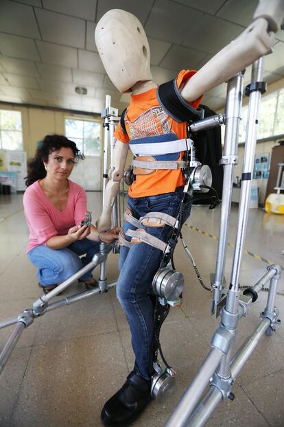 Elena García junto a un exoesqueleto, responsable del proyecto ATLAS. Pertenece al Grupo de Robótica de Exteriores y de Servicios del CAR. Estos trabajos tienen como finalidad avanzar en el estado de la técnica de los dispositivos robóticos de asistencia a la locomoción mediante el desarrollo de nuevos actuadores, nuevos sistemas eficientes de control de la locomoción, y nuevos exoesqueletos de miembro inferior. Centro de Automática y Robótica (CAR).