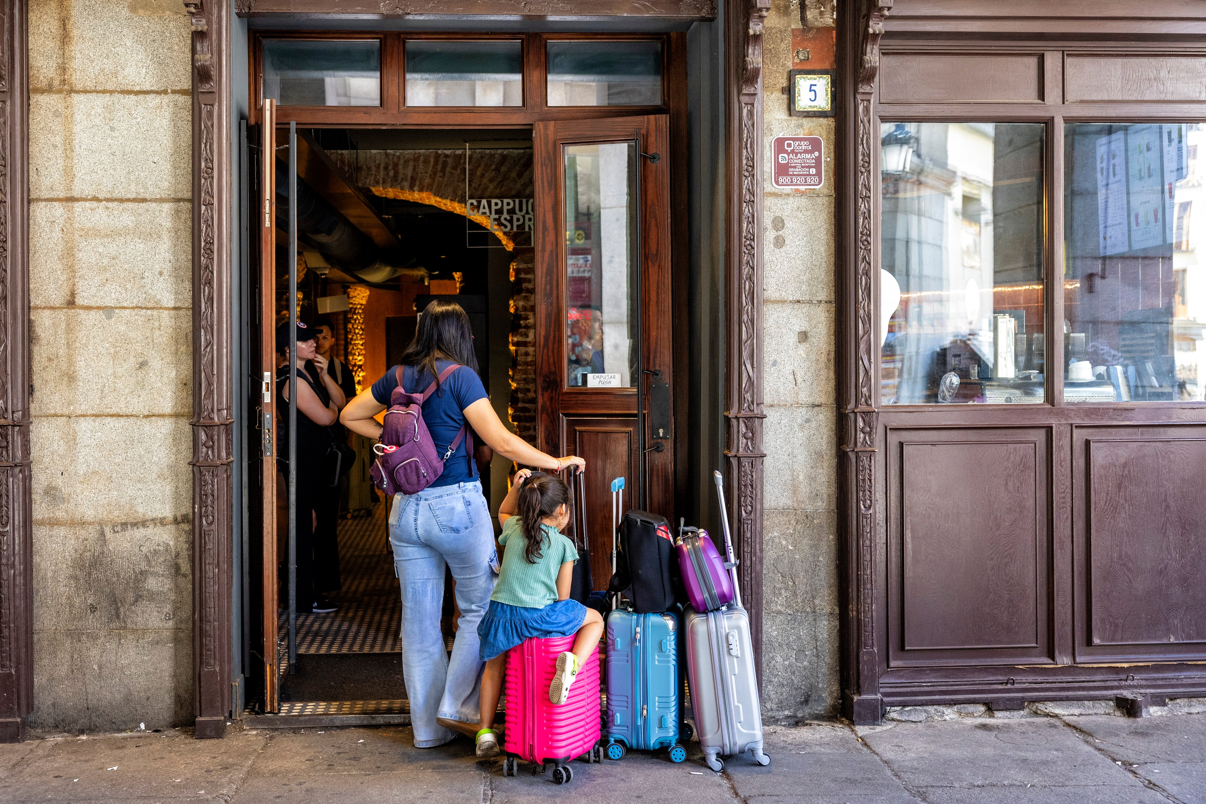 Una turista y su hija en la puerta de una cafetería en el centro de Madrid.