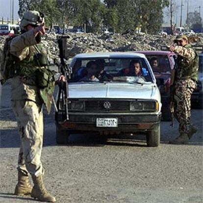 Un soldado estadounidense y un miembro de la Defensa Civil iraquí, ayer, en un puesto de control en Bagdad.