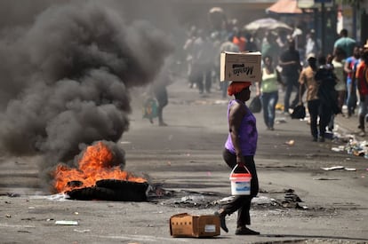 Uma mulher passa uma barricada na comuna de Petion Ville, em 17 de fevereiro.