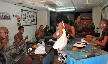 Varios empleados estatales trabajan en una zapatería de La Habana.