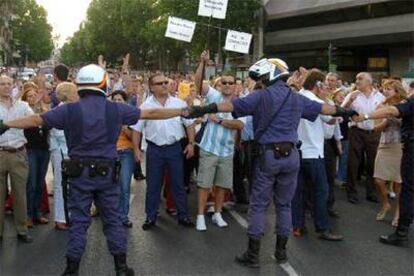 En la imagen, un grupo de afectados por la estafa se enfrenta a la policía.