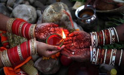 Dois fiéis indianos acendem velas próximo ao rio Tawi, em Jammu, capital de verão da Caxemira indiana.